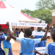 Girl holding a sign that reads HIV FREE GENERATION